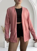 Blazer rosado de crepé con corte recto, solapas y bolsillos frontales.
