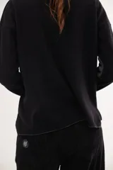 Buzo de escote en V y manga larga, confeccionado en lana lambswool. Presenta un diseño básico con detalle de raya en contratono en una de las mangas, puños y ruedo en color contrastante, y pin metálico de la marca aplicado en la manga.