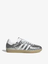 Championes Adidas Samba LT con acabado metálico plateado y textura de piel de serpiente. Presenta las icónicas tres tiras blancas en los laterales, suela de goma color caramelo y cierre de cordones.