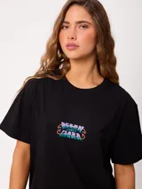 Remera blanca con estampado colorido en la espalda con motivos marinos, cangrejos y caracoles, de manga corta y ajuste holgado.