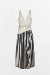 Vestido largo de tirantes con escote redondo, confeccionado en mezcla de viscosa. Presenta un diseño combinado con la parte superior en tejido ligero semitransparente y la parte inferior con volumen y drapeado asimétrico.