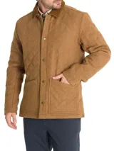 Chaqueta marrón acolchada con patrón de rombos, cuello de pana marrón, cierre con broches metálicos, bolsillos frontales y bolsillo interno. Confeccionada en lana con relleno Thermore de fibras recicladas.