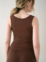 Musculosa básica entallada de tela pointelle color blanco, con escote redondo y detalle de ondas en los bordes.