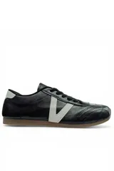 Championes casuales Vetter para mujer, de color negro con una franja lateral blanca en forma de V y suela de goma marrón. Presentan cordones negros y detalles pespunteados en la puntera.