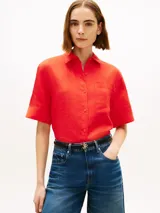 Camisa de manga corta de corte amplio color rojo, confeccionada en puro lino. Cuenta con cuello inglés, bolsillo de parche en el pecho con logo bordado y hombros ligeramente caídos.
