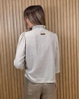 Camisa de algodón color blanco, con cuello alto con volados, mangas tres cuartos con detalles de bordado ingles y cierre frontal con botones de nácar.