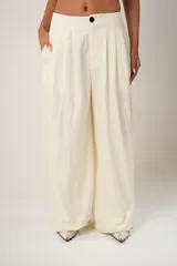 Pantalón de vestir color crema, de corte sastre clásico y pierna ancha.