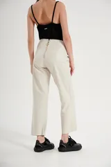 Pantalón de cuero color beige, de corte recto, con cintura alta y lazo para ajustar.