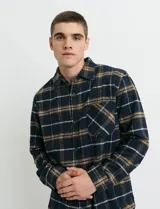 Sobrecamisa de manga larga con diseño a cuadros, cuello camisero y bolsillo frontal. Confeccionada en tejido de poliéster y algodón, sin forro.