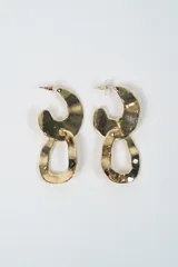 Aros colgantes de diseño moderno, compuestos por dos eslabones irregulares de metal con acabado brillante en tono dorado.