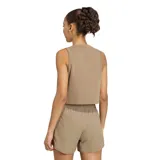 Top deportivo Adidas modelo We Tank, color beige, sin mangas, con cuello redondo y el logo de la marca estampado en blanco en el pecho.