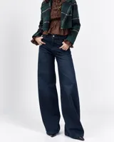 Pantalón de jean azul oscuro, de tiro medio y corte wide leg holgado, con bolsillos delanteros y traseros.