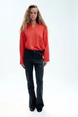 Jeans Zara Woman Collection de tiro alto y corte flare, confeccionados en denim azul marino con diseño de rayas diplomáticas. Presenta falsos bolsillos delanteros con solapa y botón, raya planchada central y cierre frontal con cremallera y botón metálico.