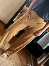 Pantalón tiro medio color tostado, confeccionado en plush de algodón, de corte recto y holgado. Cuenta con faja ancha en la cintura para mayor sostén y bolsillos delanteros aplicados.
