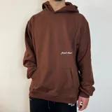 Canguro marrón con capucha, corte oversize, bolsillo tipo canguro y puños y cintura acanalados.