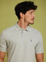 Remera polo gris de manga corta con logo bordado en el pecho.