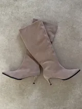 Botas altas de cuero vacuno gamuzado en color tostado, con diseño de caña recta, punta fina y tacón fino.