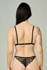 Conjunto de lencería negro de encaje, compuesto por un bralette de copas triangulares con breteles regulables y una tanga regulable tipo media less con detalles de encaje.
