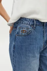 Jean balloon de color azul con lavado vintage, tiro medio, diseño amplio en las piernas y dobladillos inferiores elastizados.