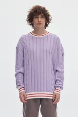 Buzo de punto color lila con tejido de ochos, cuello redondo a la base y detalles en contraste a rayas blancas y rojas en el cuello, puños y ruedo.