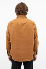 Camisa de pana color camel, de corte recto, con cuello abotonado y bolsillo en el pecho.