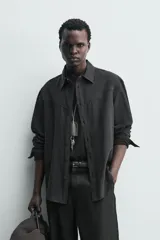 Camisa de corte regular confeccionada en tejido fluido con mezcla de lyocell, cuello solapa, manga larga con puños abotonados y cierre frontal de botones.