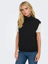 Chaleco tejido de punto con diseño de trenzas, cuello alto tipo polera y terminaciones acanaladas en el ruedo y sisas.