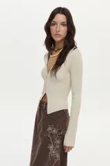 Falda larga de denim marrón, de corte evasé con paneles tipo godet y bordado floral en el lateral.