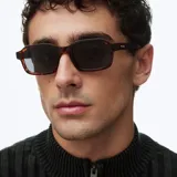 Lentes de sol con montura cuadrada de carey y lentes oscuras polarizadas con protección UV.