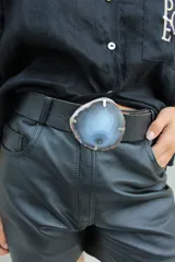 Cinto de cuero azul con hebilla circular de piedra ágata con borde dorado.