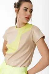 Remera de punto color beige con recortes curvos en amarillo.