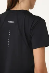 Remera deportiva negra de poliéster y elastano, con recortes laterales y traseros.