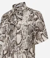 Blusa de chiffon con estampado de serpiente en tonos beige y marrón. Tiene cuello alto con lazo y mangas cortas.