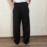 Pantalón sastrero color beige, de corte baggy, con pliegues en la cintura y bolsillos laterales.