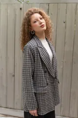 Blazer de paño con estampa a cuadros en tonos marrones y beige, de corte recto y mangas largas.