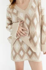 Sweater oversize con cuello en V y estampado de rombos en tonos lila, rosa y rojo. Tejido de lana artesanal.