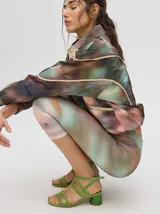 Calza deportiva 3/4 de tiro alto, confeccionada en lycra con un diseño estampado abstracto en tonos tierra, verdes y rosados.