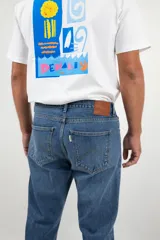 Pantalón jean de corte recto clásico con cinco bolsillos, botones de cobre y costuras color camel.