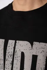 Remeron de corte oversize color negro, con estampa frontal en color gris desgastado que incluye el texto 'CNPT' y tres estrellas. Presenta cuello redondo y mangas cortas amplias.
