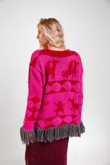 Sweater de lana merino tejido a mano con diseño geométrico y figuras de llamas, corte holgado con cuello redondo y flecos decorativos en el ruedo.