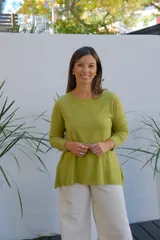 Sweater de punto color verde oliva, con cuello redondo, manga larga y corte holgado con ruedo asimétrico.