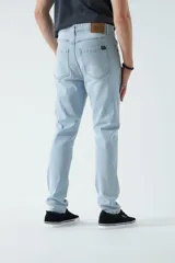 Pantalón de jean azul de corte slim, tiro medio y con presillas para cinturón.