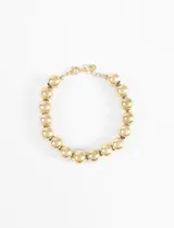Pulsera de eslabones compuesta por bolitas grandes y redondas de metal dorado, con cierre de mosquetón y cadena de ajuste.