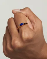 Anillo de plata bañada en oro con piedra azul facetada en forma de ojo de gato.