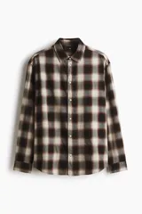 Camisa de manga larga confeccionada en franela de algodón suave, con diseño de cuadros en tonos marrones y beige. Presenta cuello inglés, cierre frontal con botones y bajo redondeado.