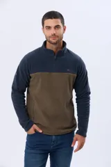 Buzo de polar texturado con diseño bicolor en azul marino y marrón, cuello alto con medio cierre y bolsillos laterales.