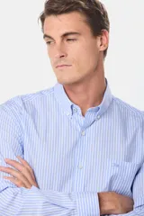 Camisa de vestir celeste con rayas verticales blancas, de manga larga y corte clásico.