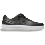 Championes Crocs InMotion Pacer de color negro con suela blanca, diseño deportivo con cordones elásticos y perforaciones laterales para mayor transpirabilidad, incorporando tecnologías LiteRide™ y Free Feel Technology™.