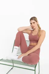 Top deportivo color ladrillo con espalda cruzada y compresión alta.