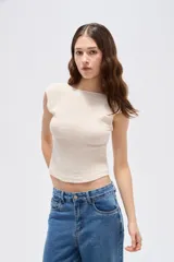 Top cropped sin mangas de poliéster en color negro, con cuello bote y diseño ajustado.